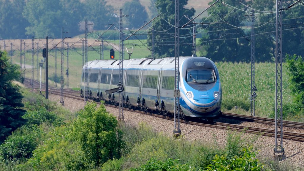 Pociąg Pendolino ED250 PKP Intercity na linii kolejowej wśród pól