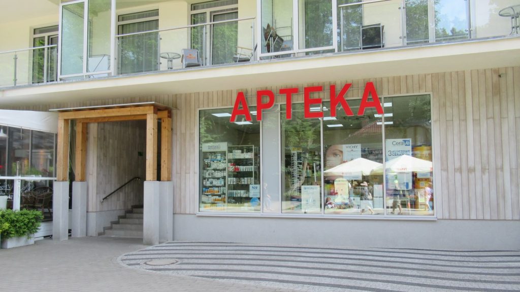 Witryna apteki z czerwonym napisem APTEKA w polskim mieście